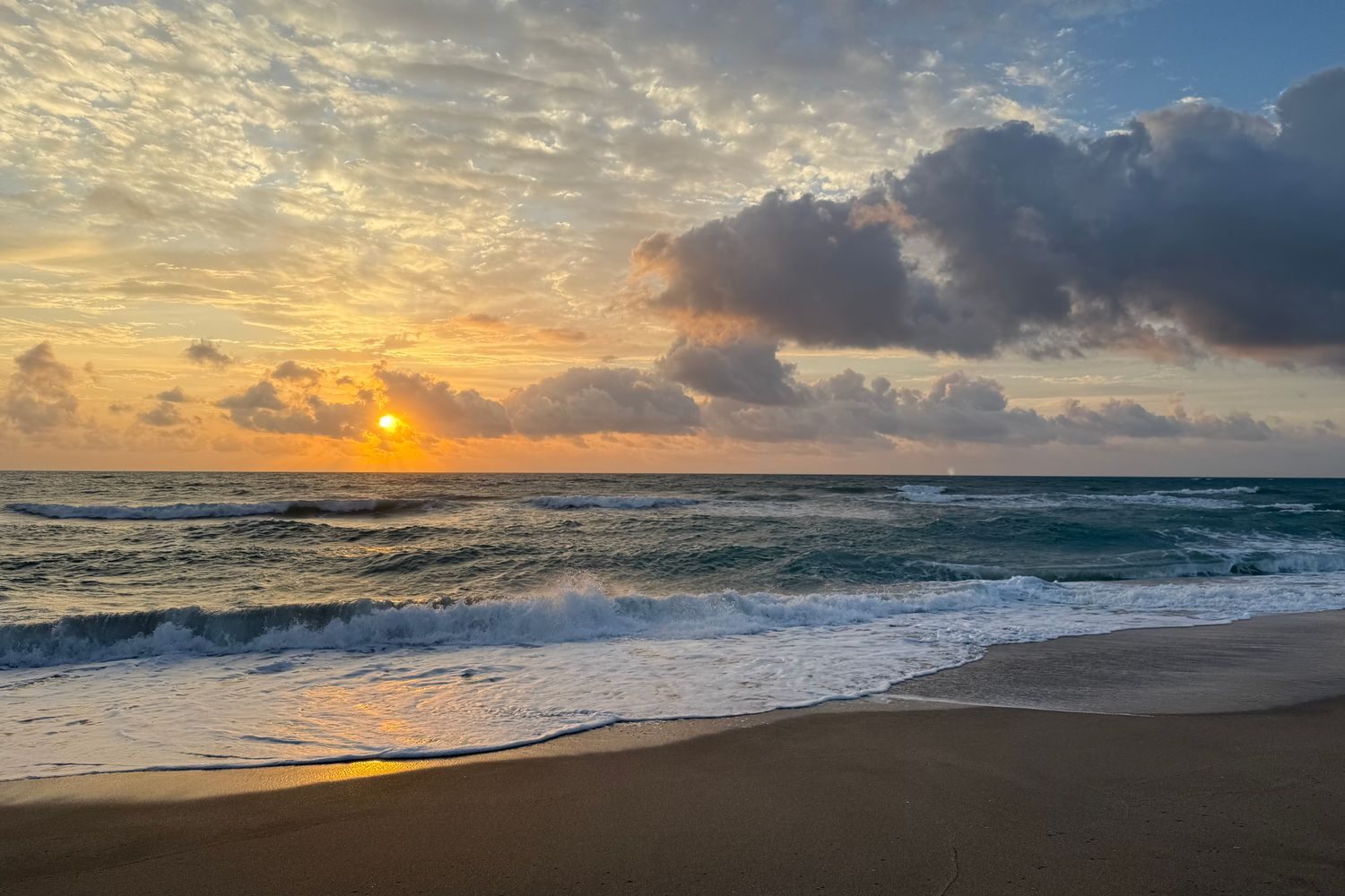 Sunrise over the Florida coast, calm open water and a quiet morning sky