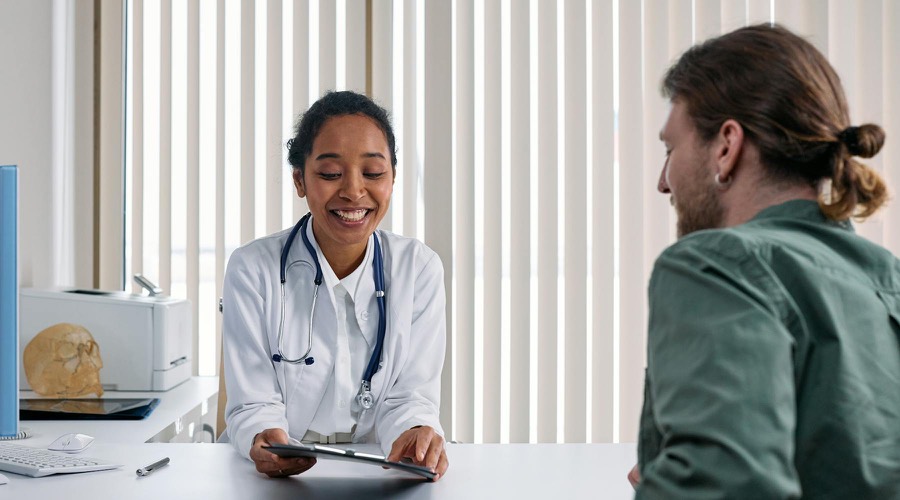 Florida-licensed physician in a bright clinic warmly consulting a patient during a medical marijuana evaluation.