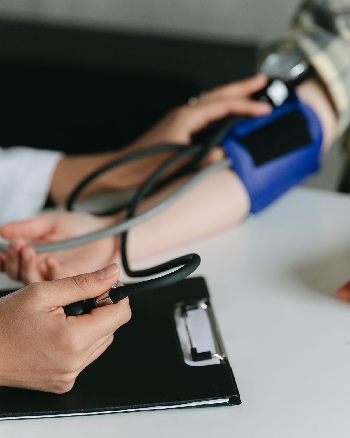 A clinician checking a patient's blood pressure during an office visit, representing medically supervised weight loss care.